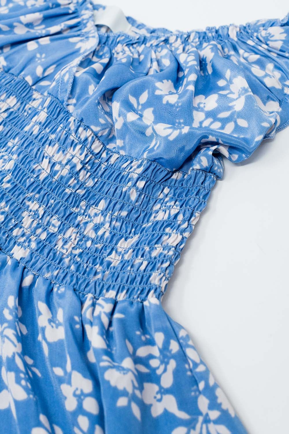 Blauwe korte jurk met witte bloemenprint en elastische taille